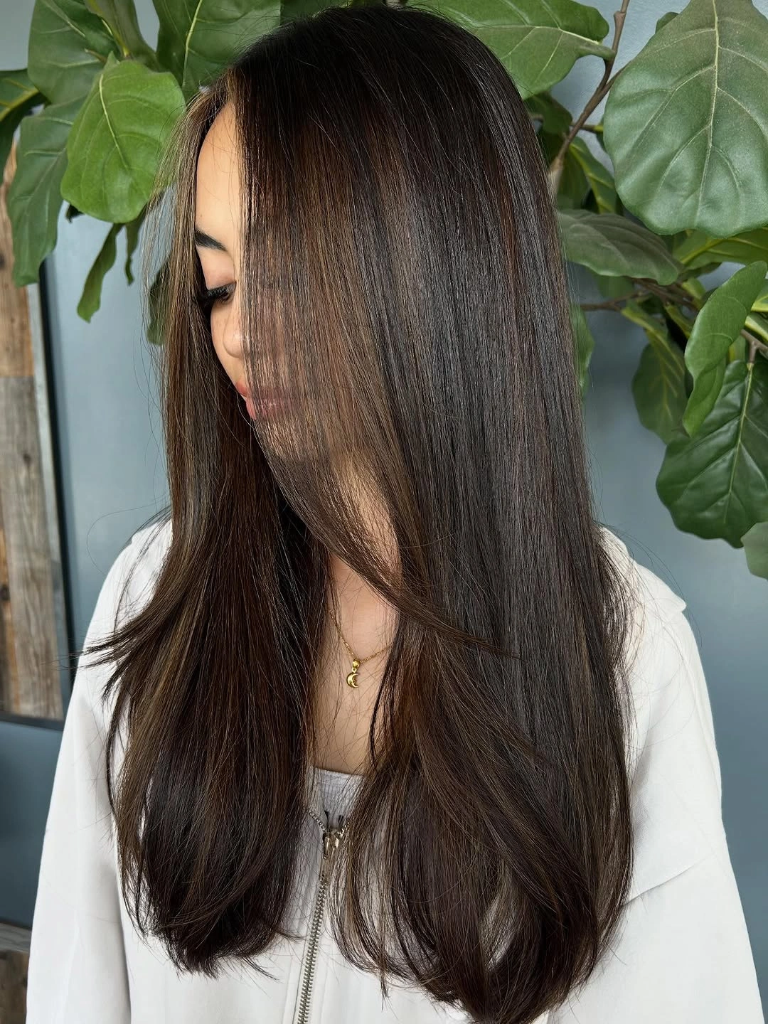 Long dark brown hair with center part and gentle taper