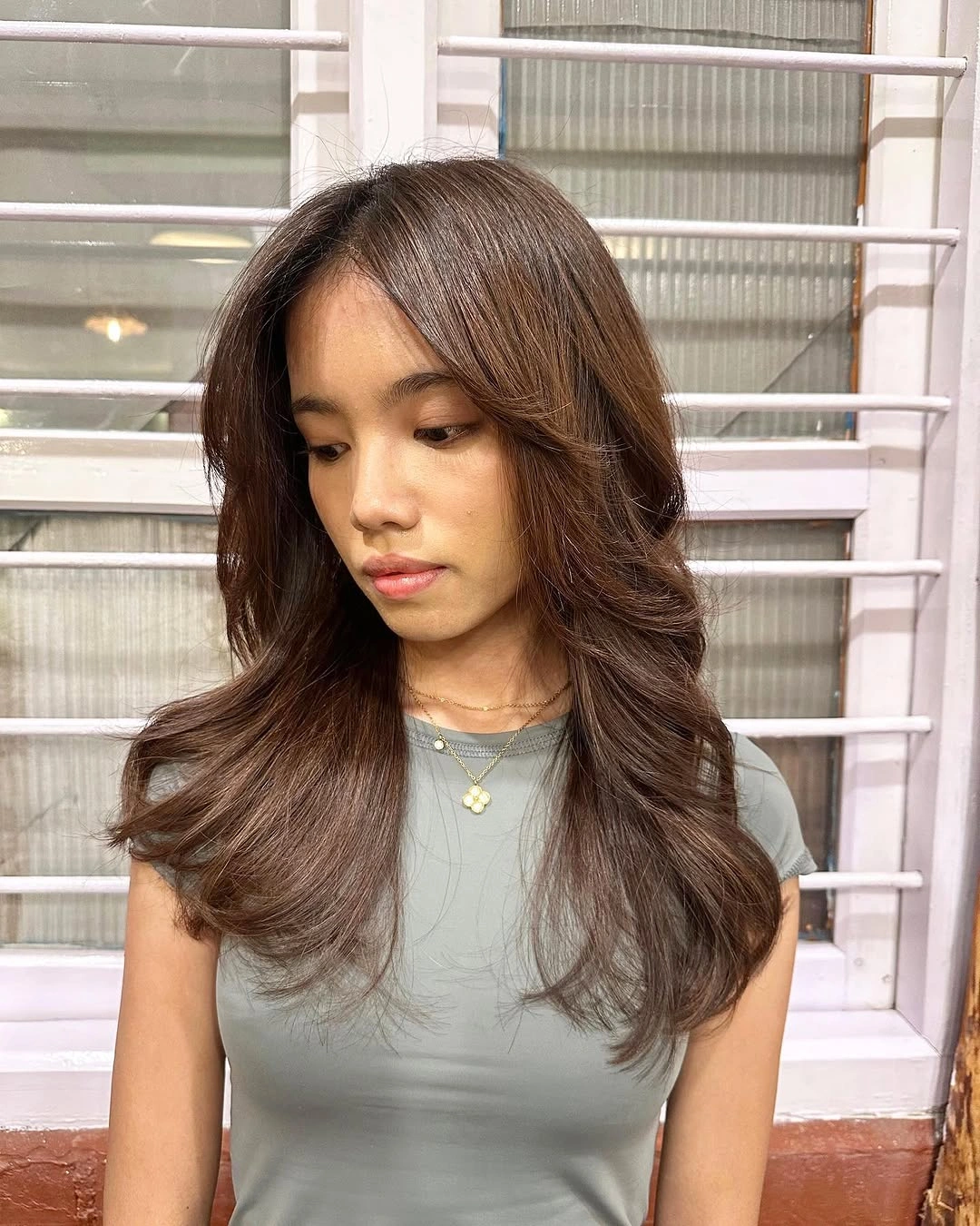 Medium brown haircut with curtain framing and outward layered bends