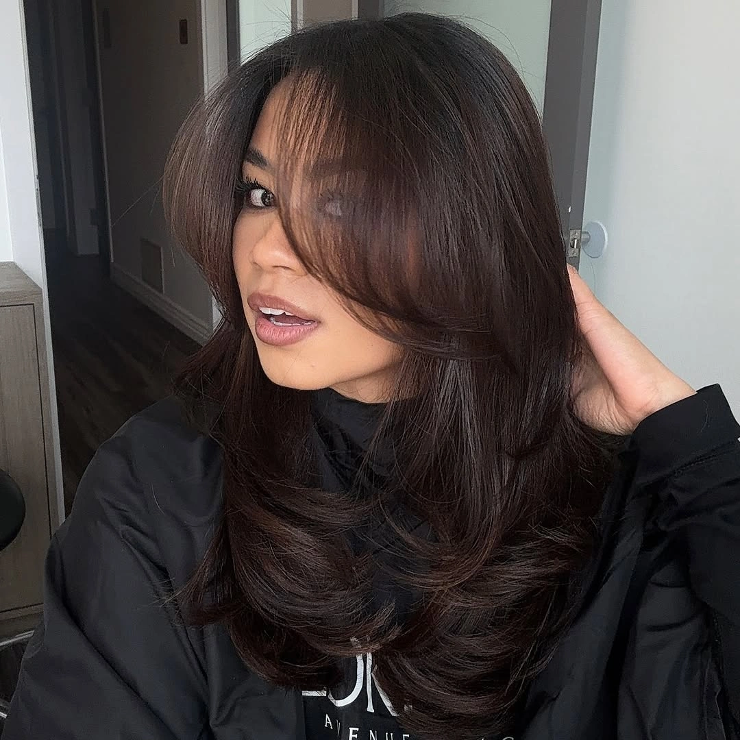 Long brunette layers with center-parted curtain fringe and curved ends