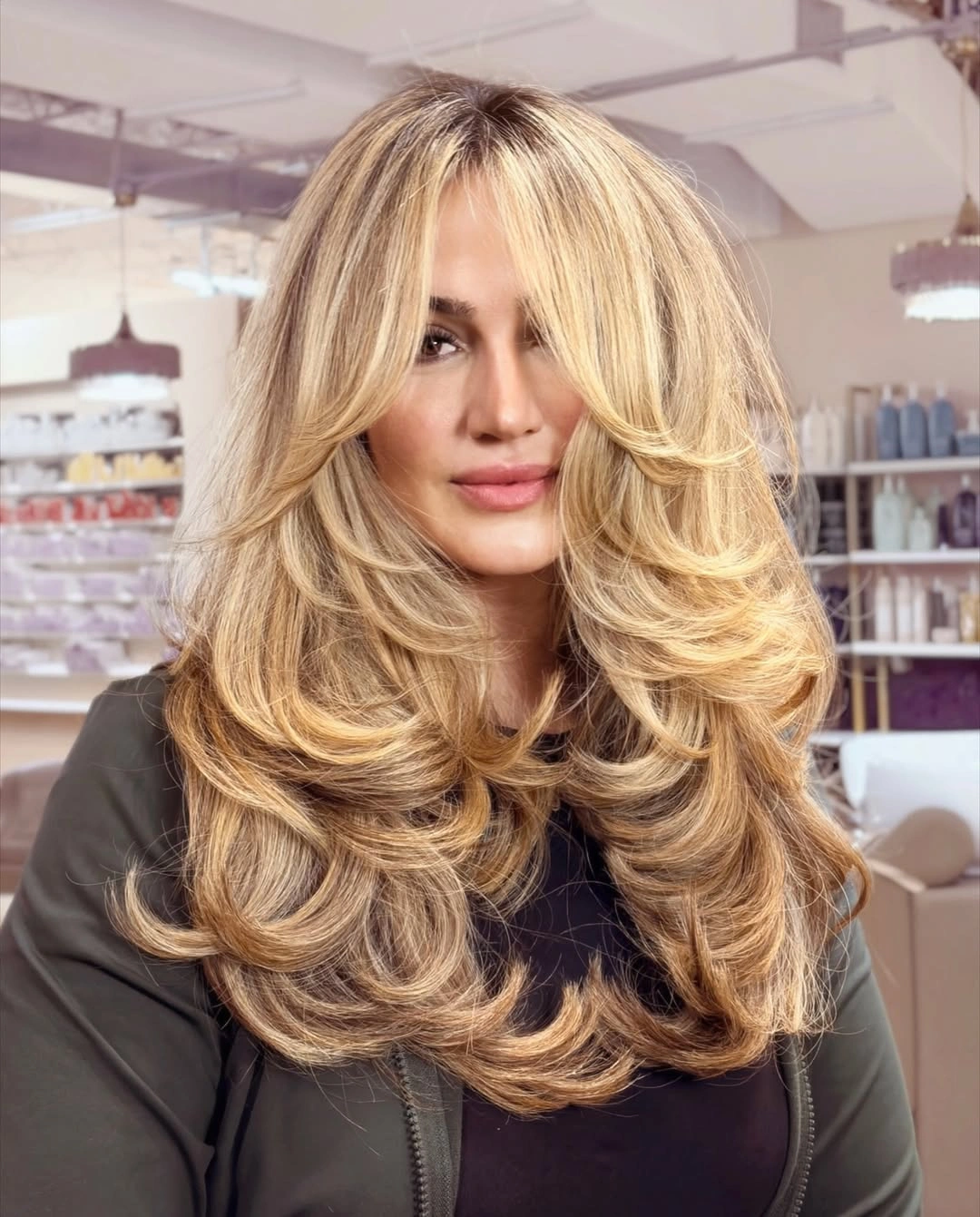 Long blonde haircut with curtain fringe and feathered curved layers