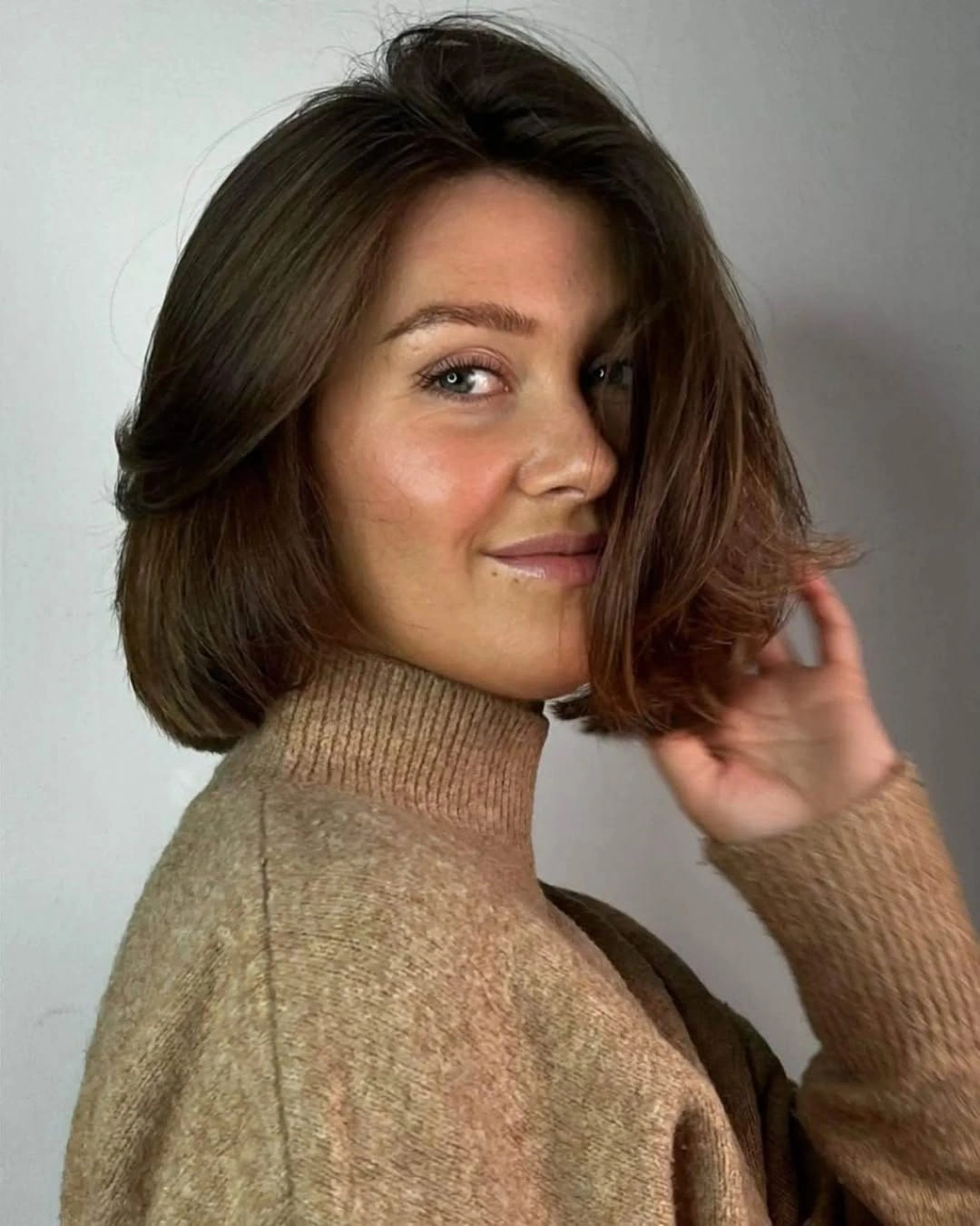 Warm brunette jaw-length bob with side part and curved ends