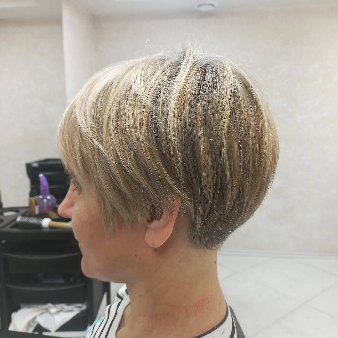 Short warm brunette pixie with side swept highlighted top