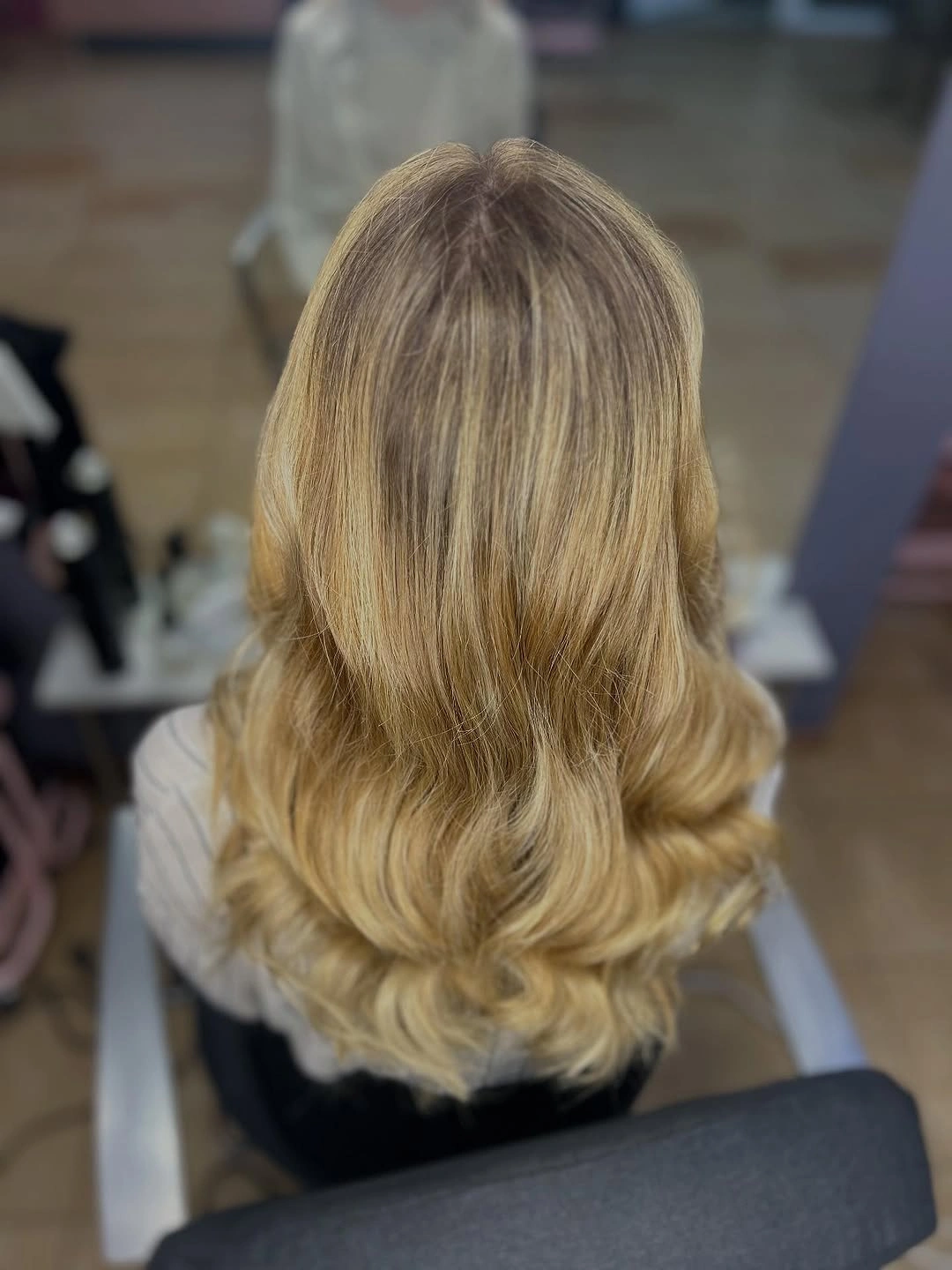Long blonde layered hair with feathered outward curving ends