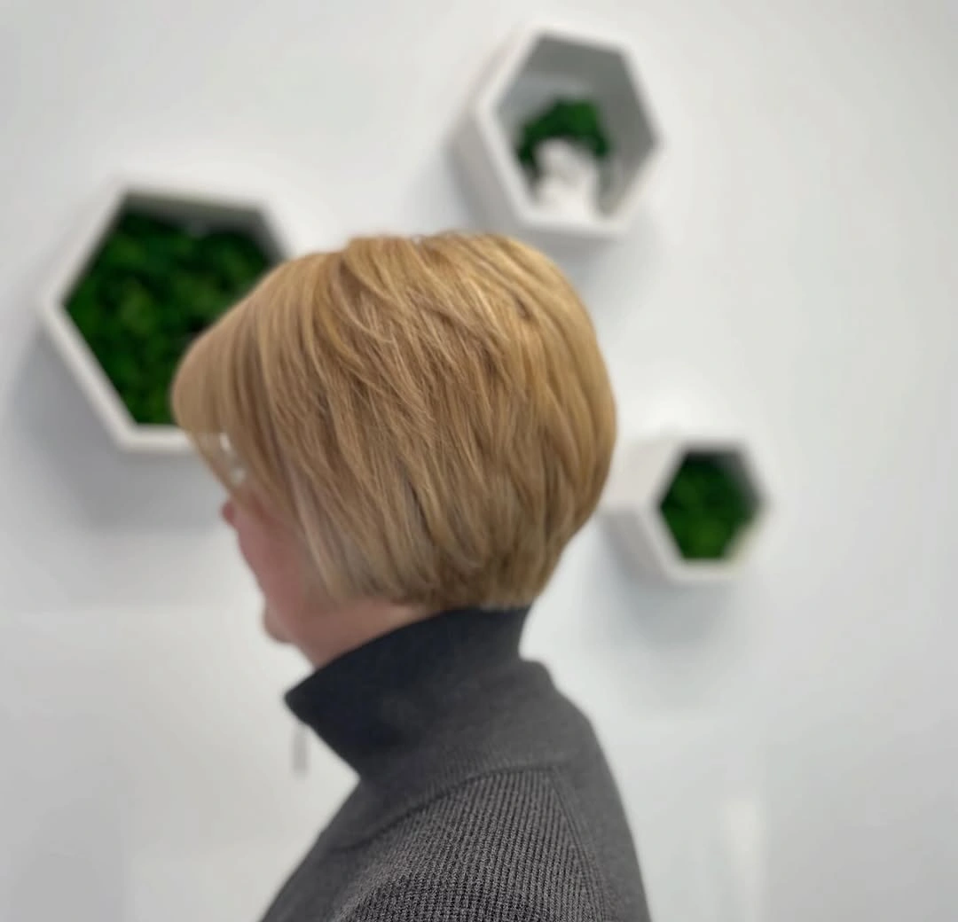Side view of short honey blonde rounded haircut
