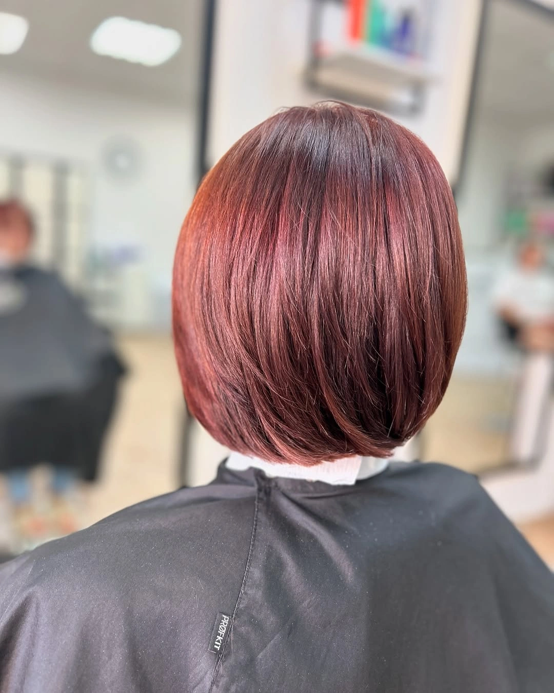 Back view of glossy burgundy rounded bob at nape