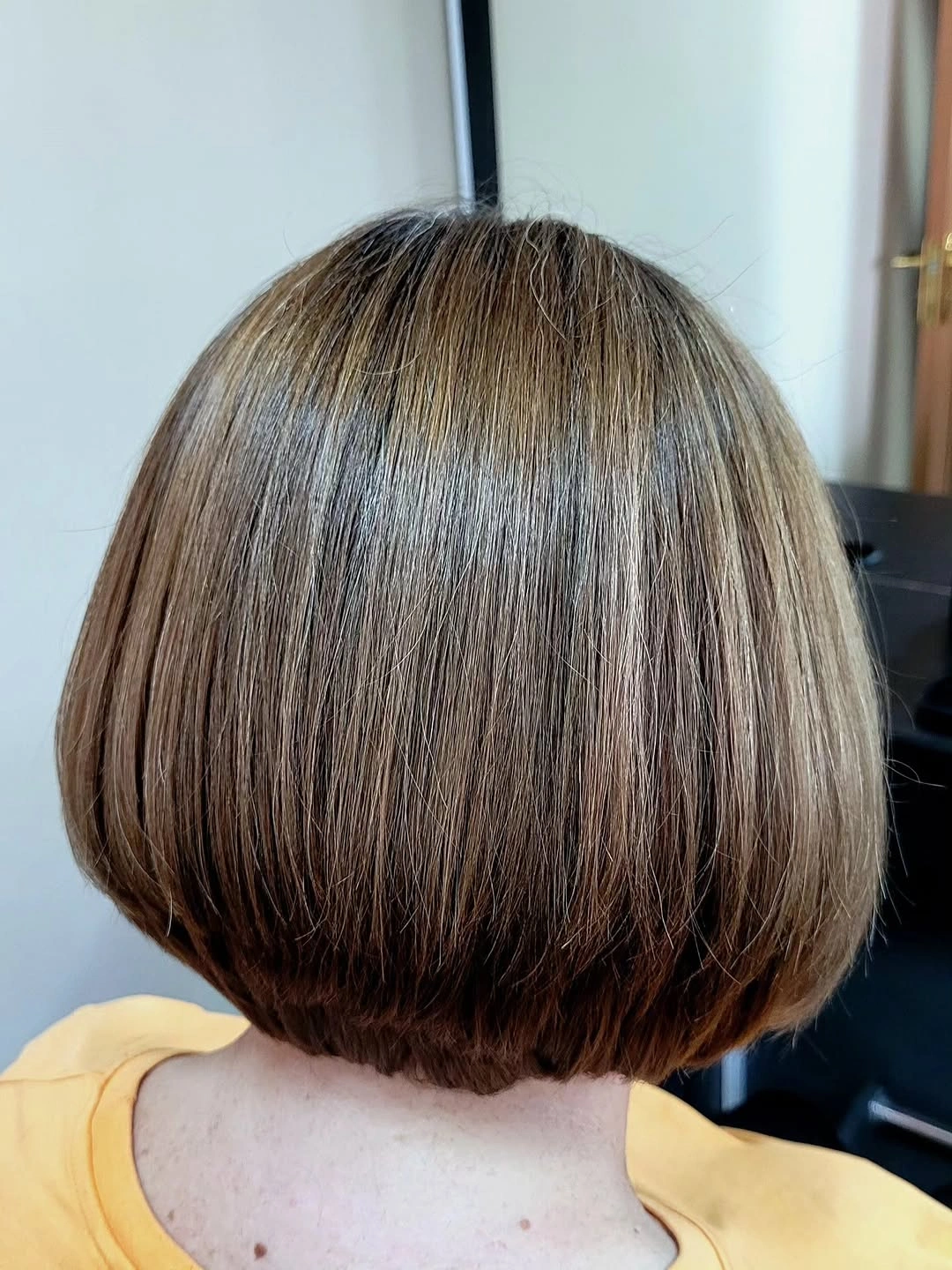 Back view of highlighted short rounded bob with tucked ends