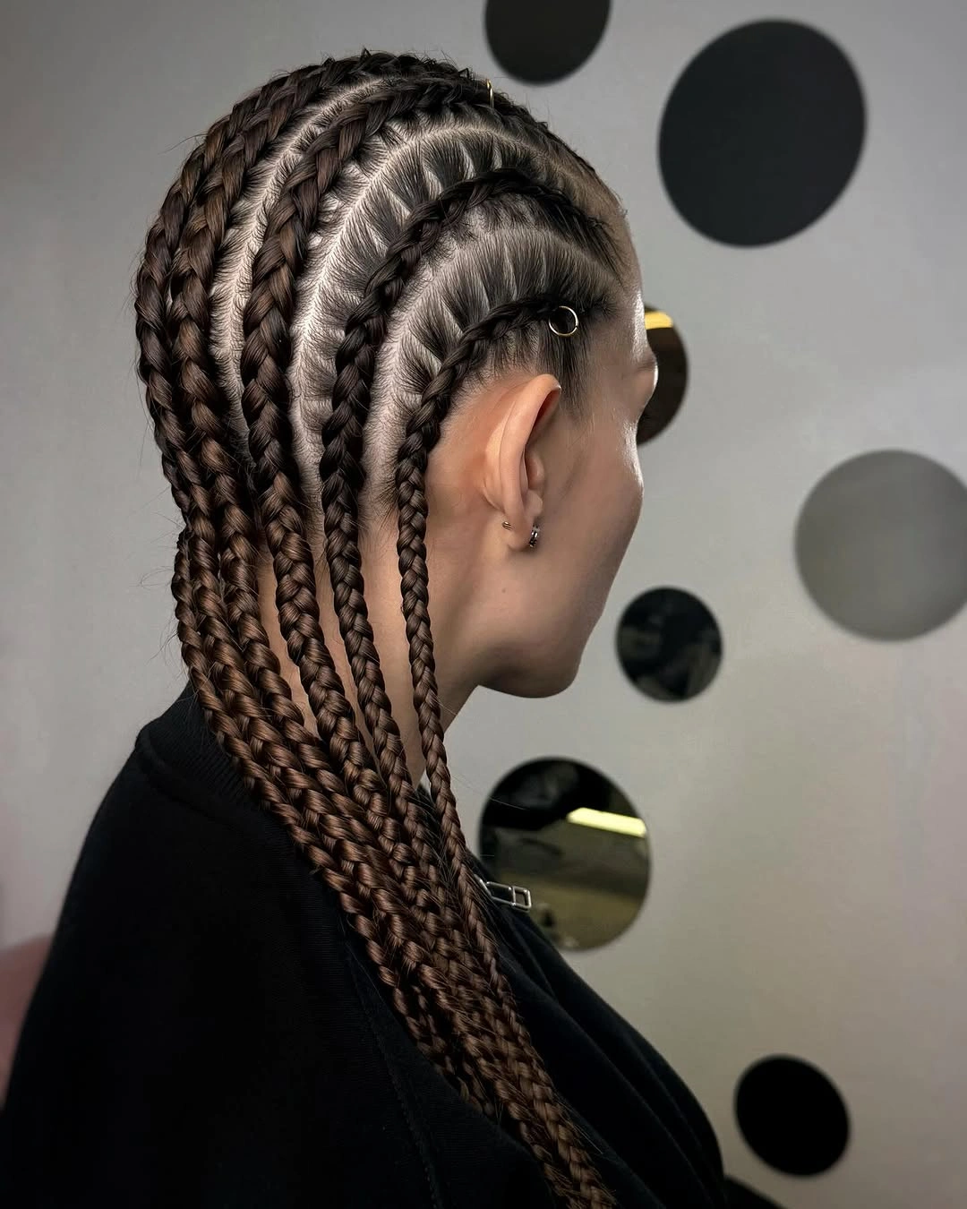 Long dark braids with arched side parting