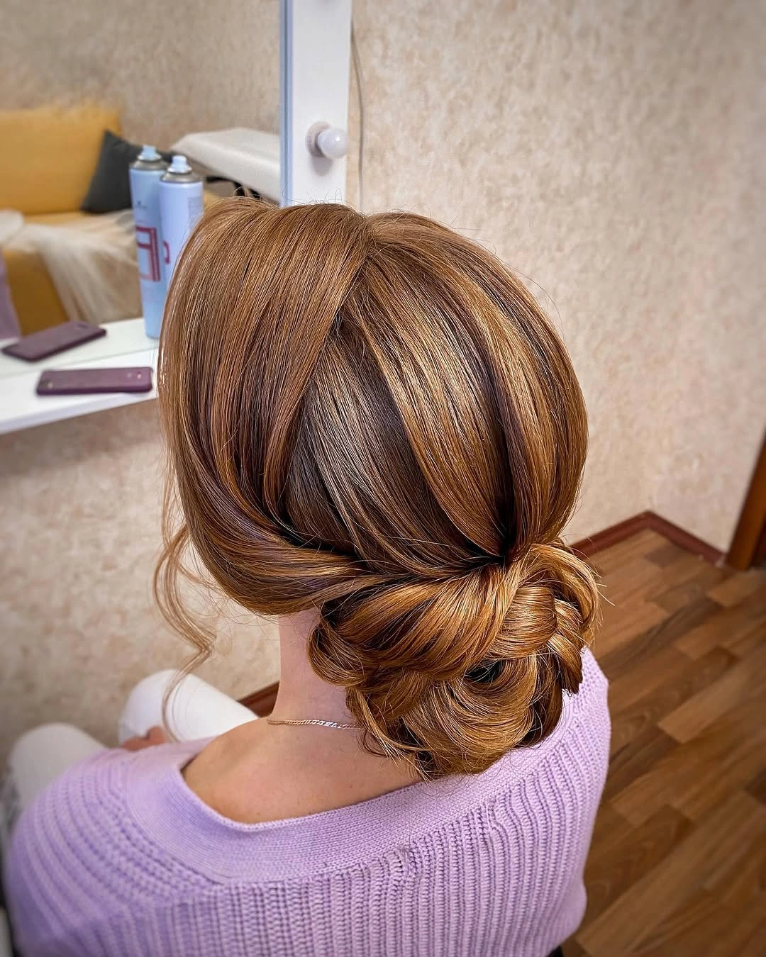 Warm brunette low bun with highlighted swept sections