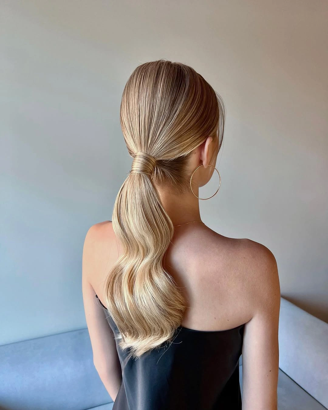 Blonde wrapped low ponytail with flowing wavy length