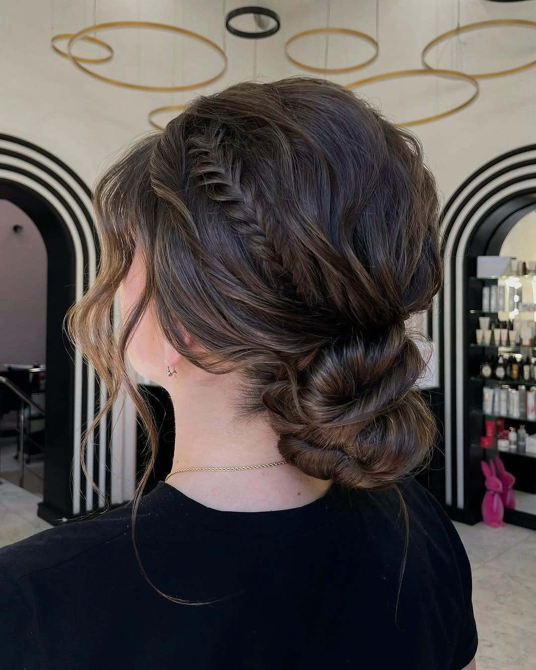 Brunette braided low bun with loose face pieces