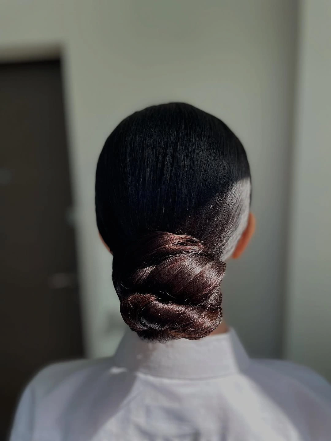 Sleek dark low bun with compact wrapped finish