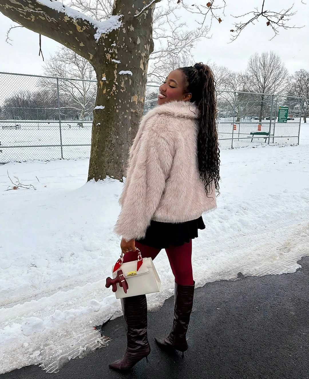 Pale plush jacket with red tights and tall dark boots