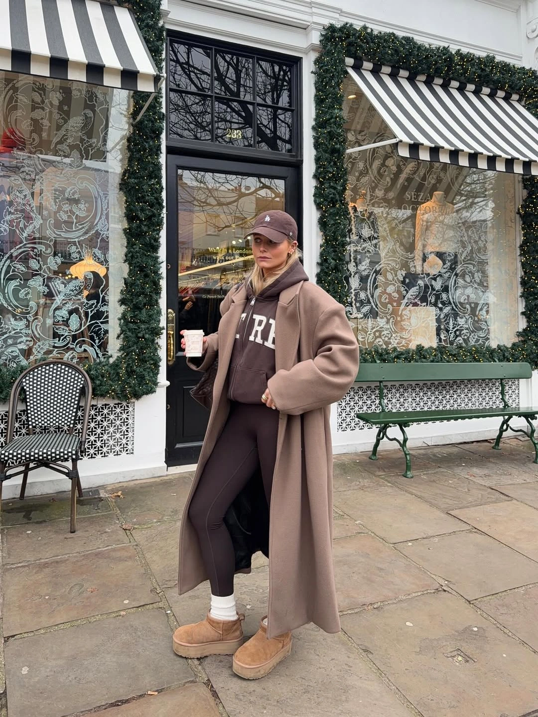 Taupe coat over brown hoodie, leggings and cap