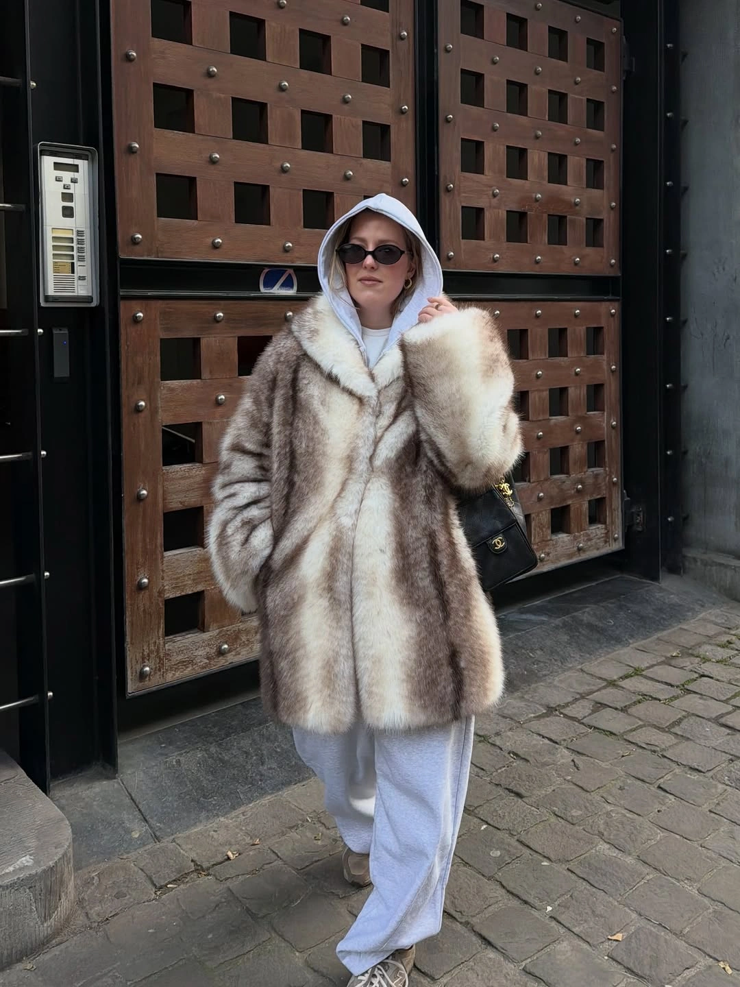 Pale plush coat with hoodie, sweatpants and dark bag