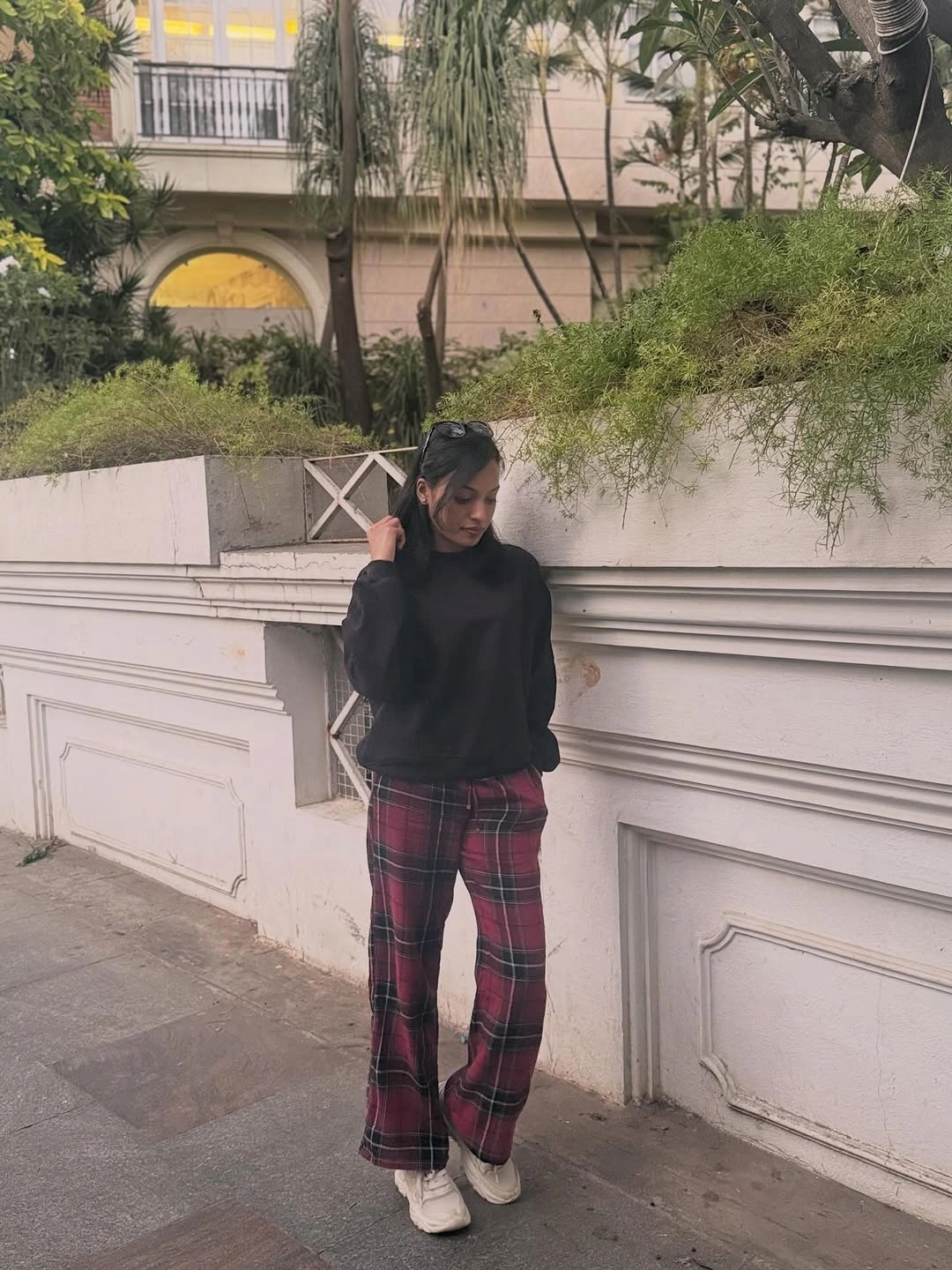 Black sweater with red plaid trousers and white sneakers
