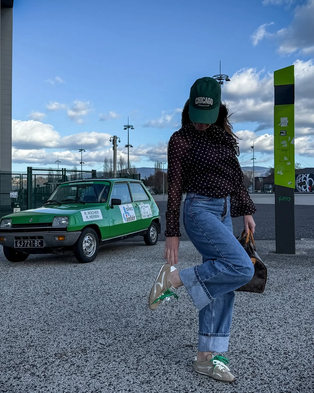 Green cap with dotted top, cuffed jeans and sneakers