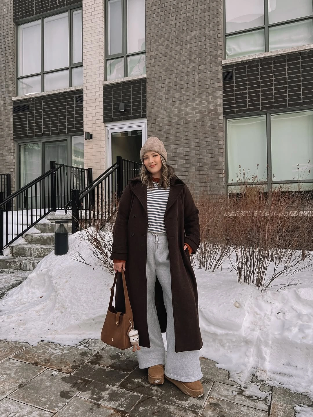 Long brown coat with stripes, gray wide legs and beanie