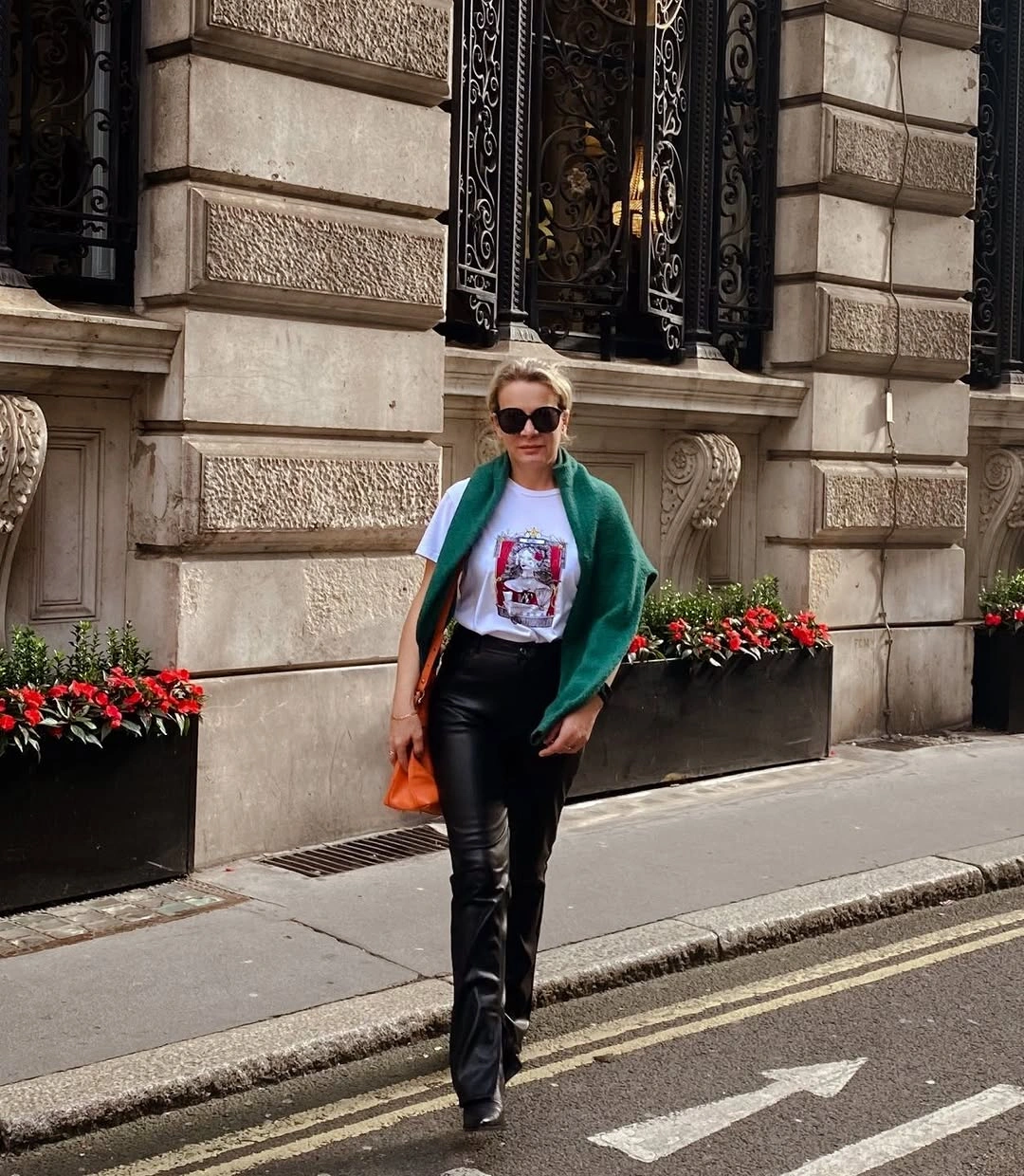 White graphic tee with green drape and glossy black flares