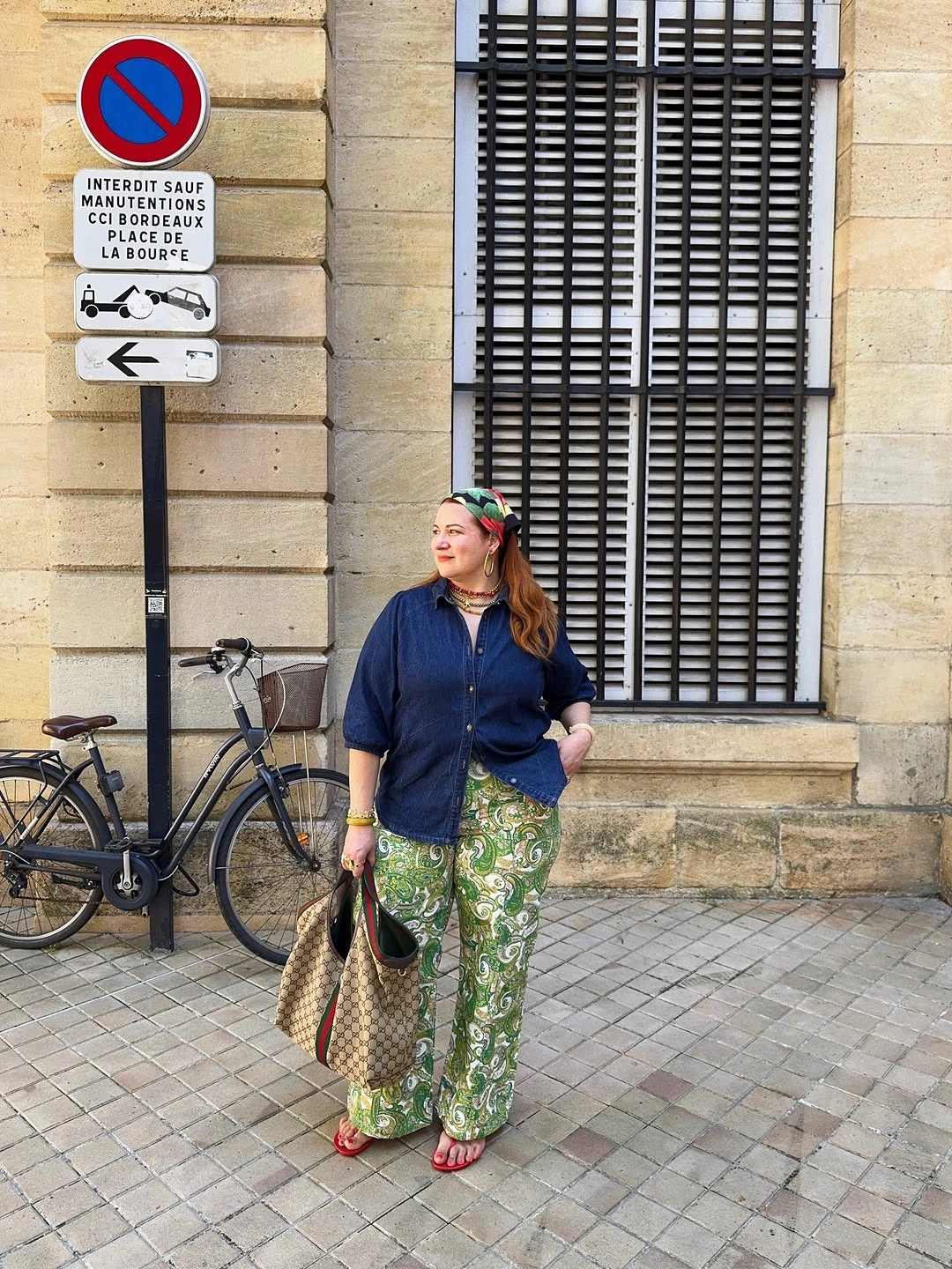 Navy button-up with green printed trousers and red sandals