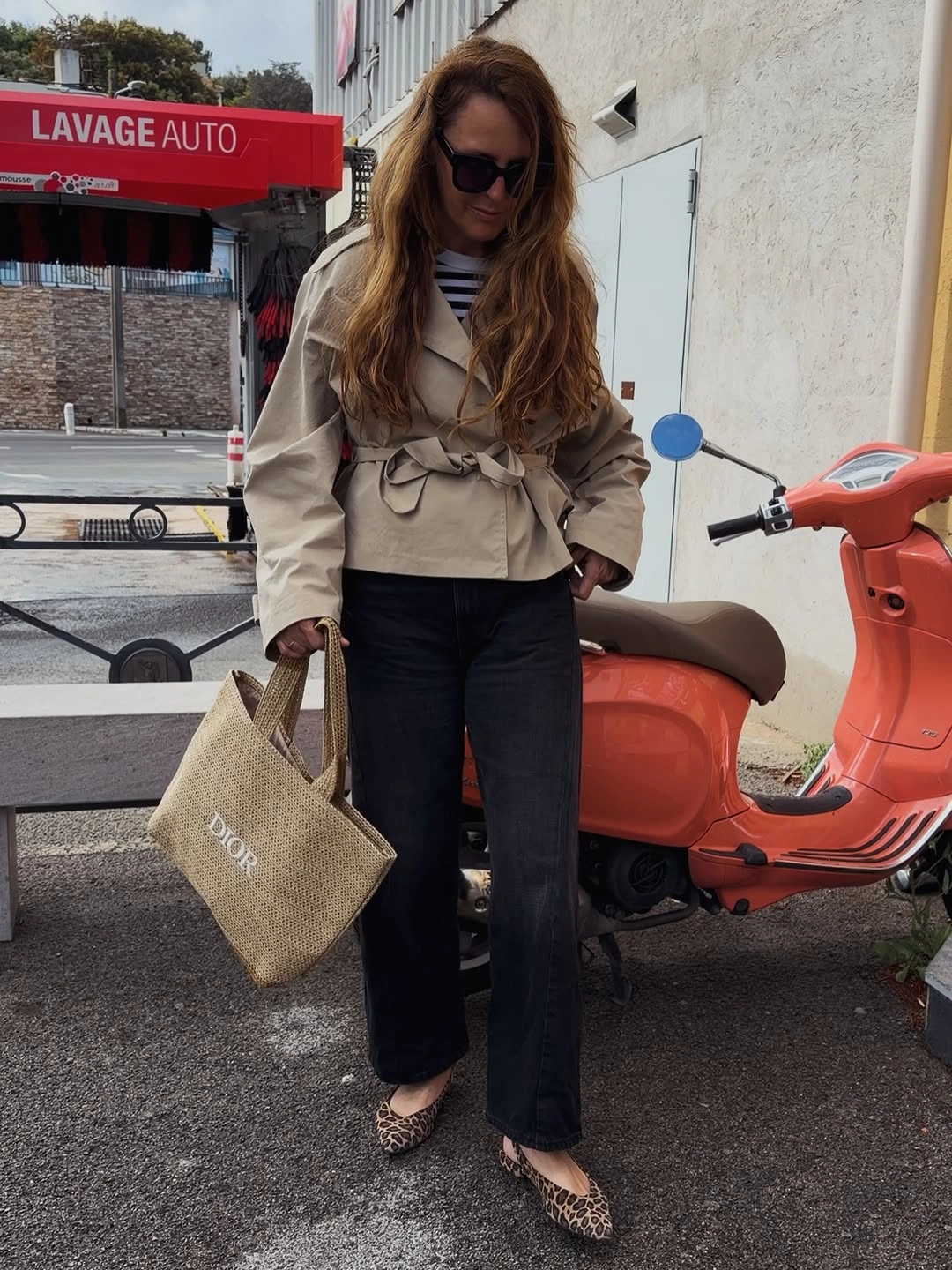 Beige belted jacket with striped top and dark wide jeans