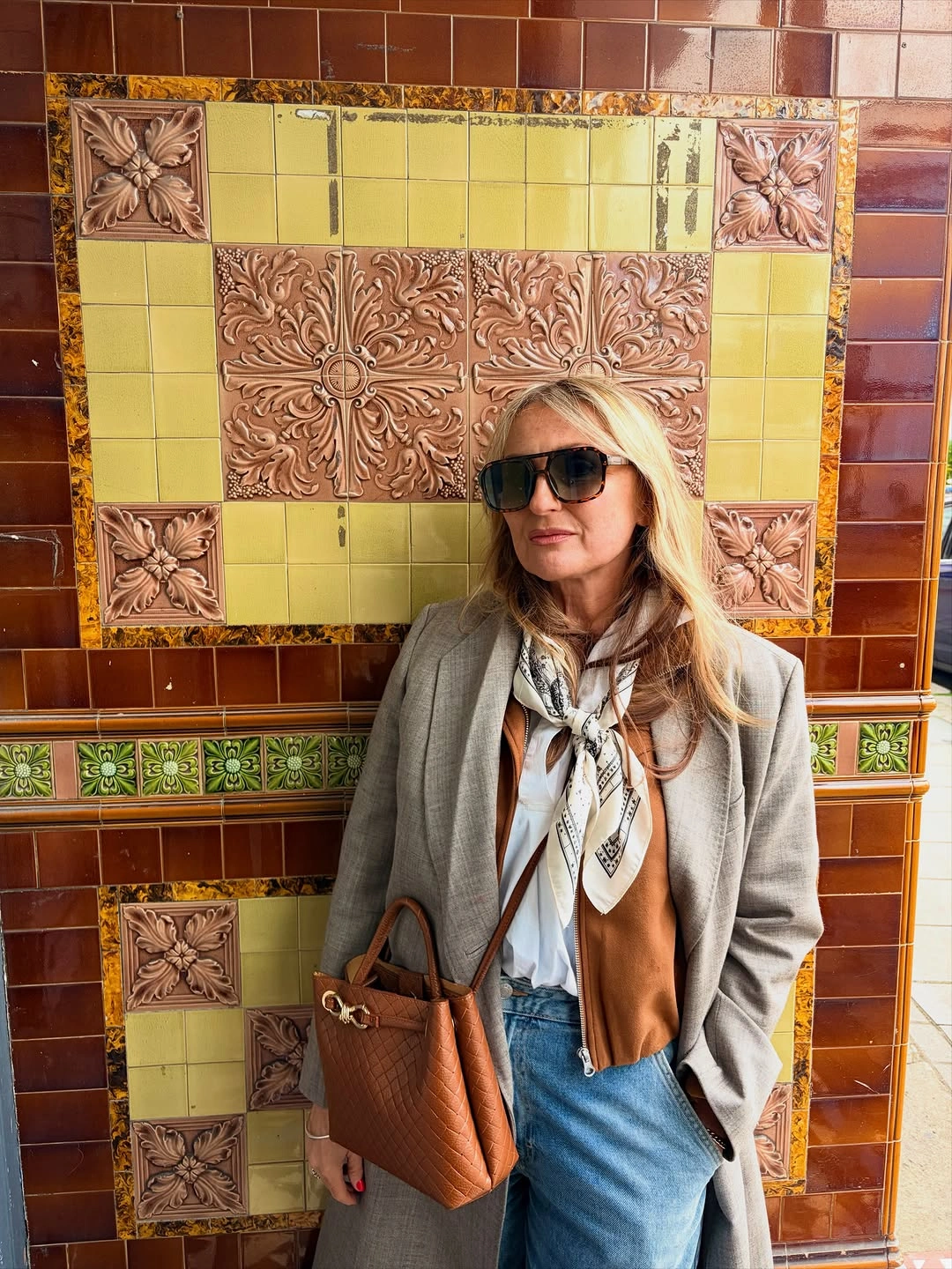 Gray coat with scarf, camel layer, jeans and tan tote