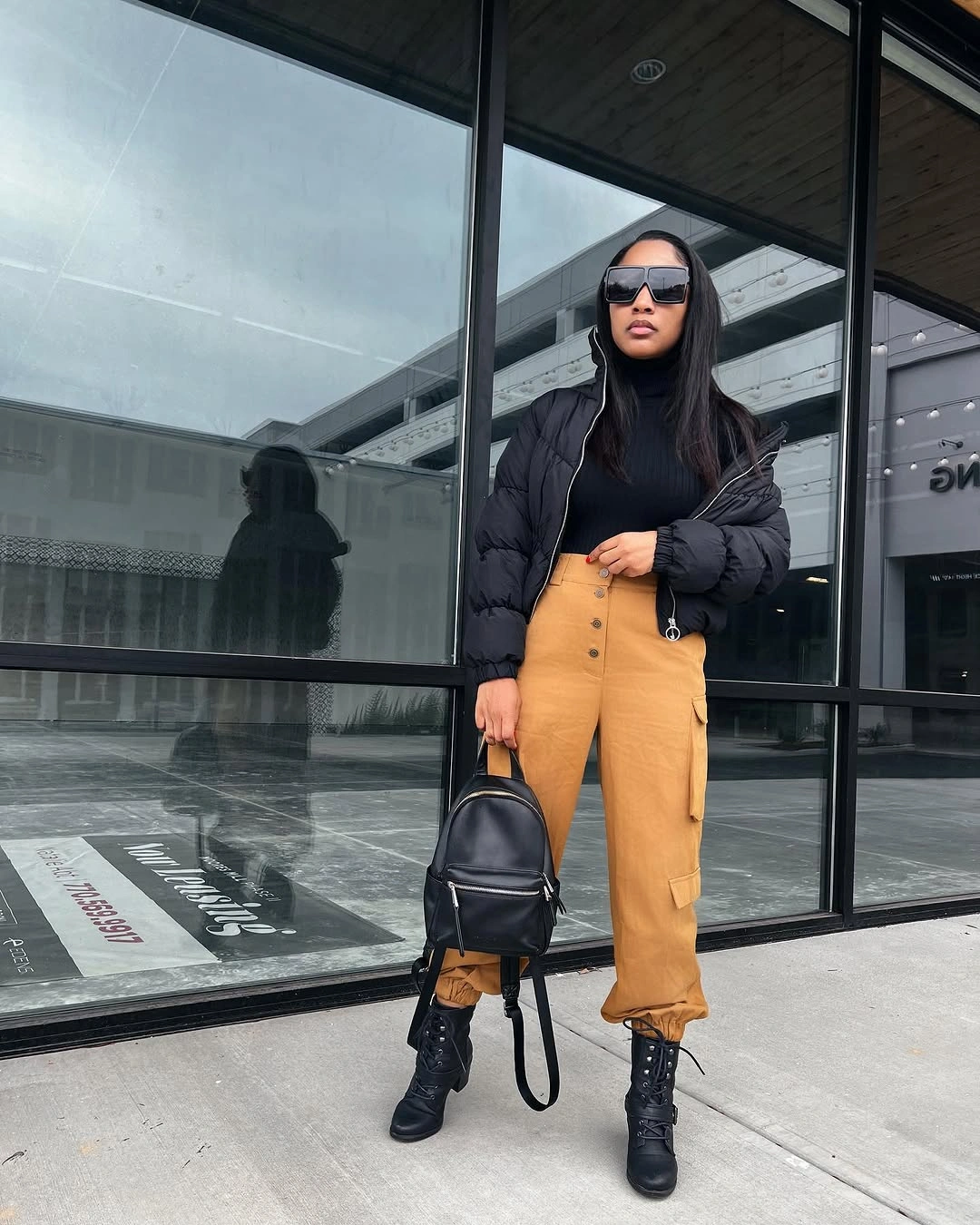 Black short puffer with mustard cargo trousers and boots