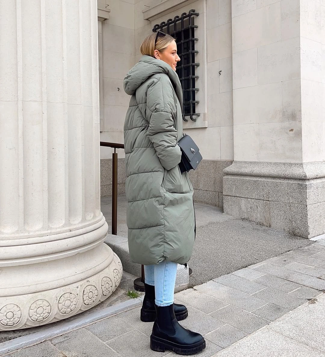 Long muted sage puffer with jeans and black boots