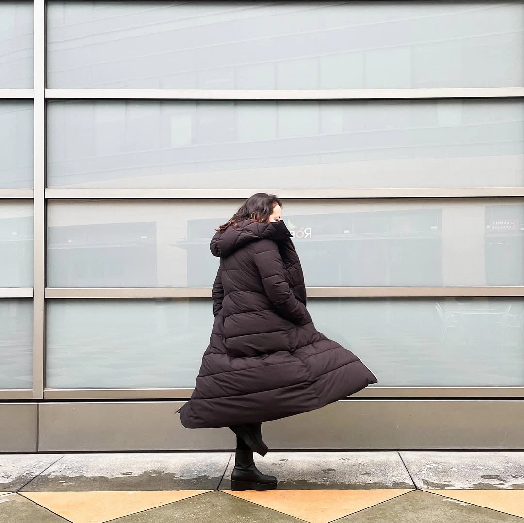 Long dark brown puffer with black leggings and boots