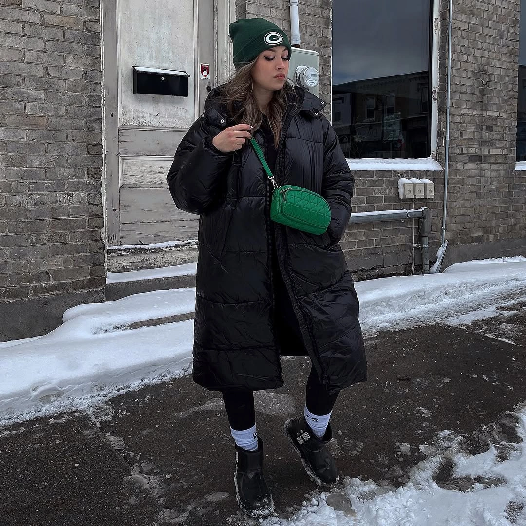 Long black puffer with green beanie and crossbody bag