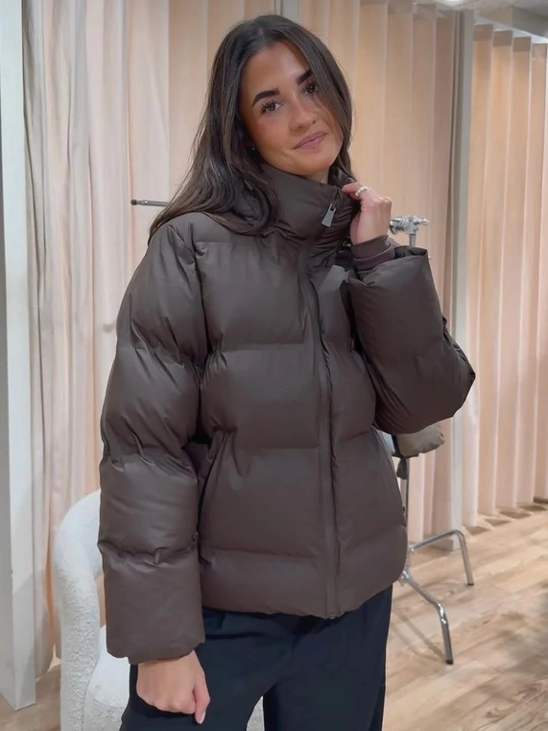 Taupe-brown cropped puffer with tall collar and dark trousers