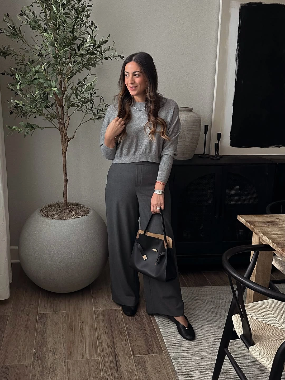 Gray long sleeve top wide trousers and black bag