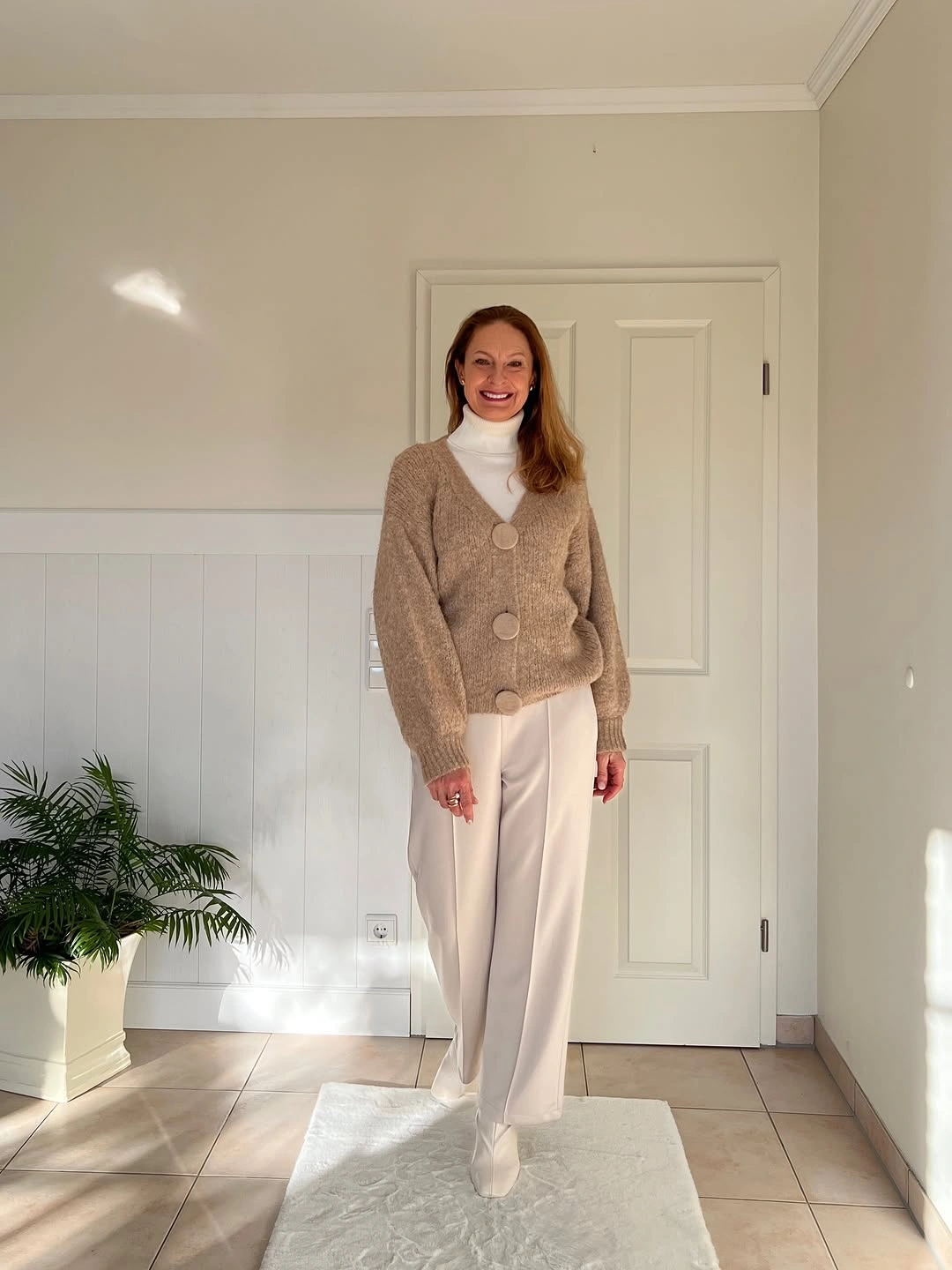 Beige cardigan white turtleneck and cream trousers outfit