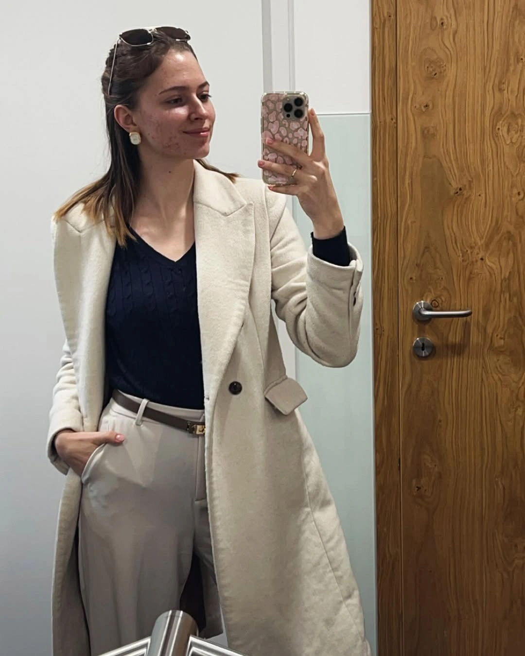 Cream long coat navy top and light trousers outfit