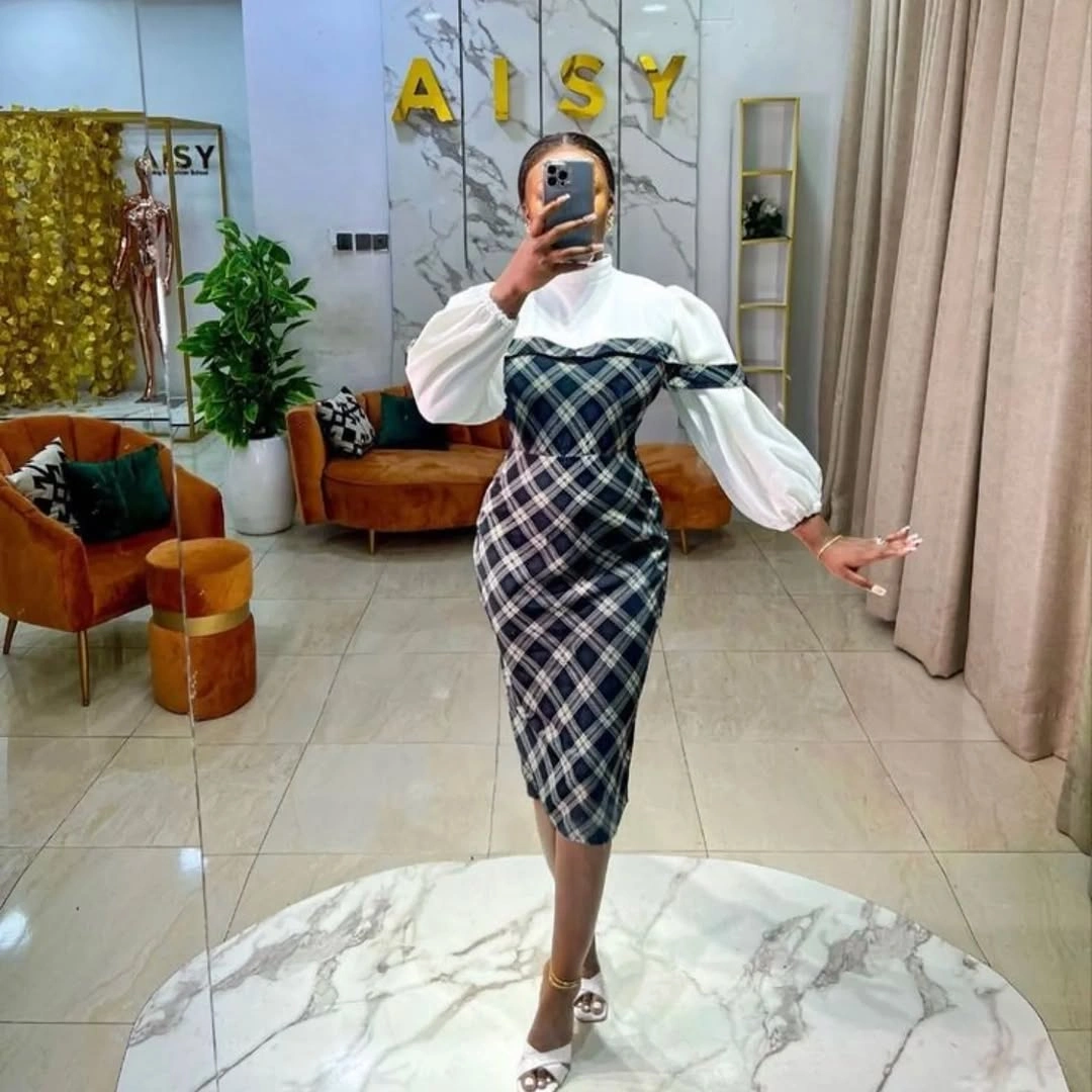 Plaid midi dress layered over white puff sleeves
