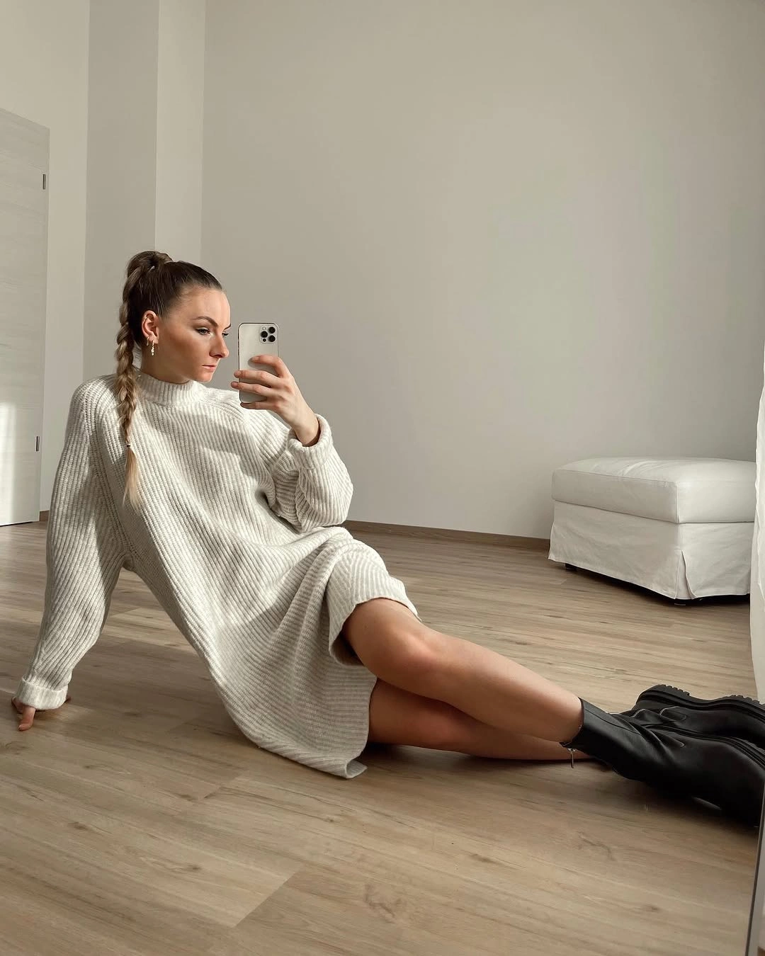 Ivory ribbed sweater dress paired with tall black boots