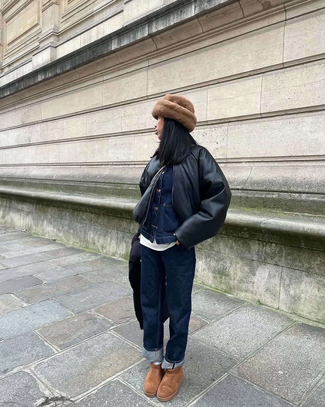 Black puffer over denim jacket with cuffed jeans and tan boots