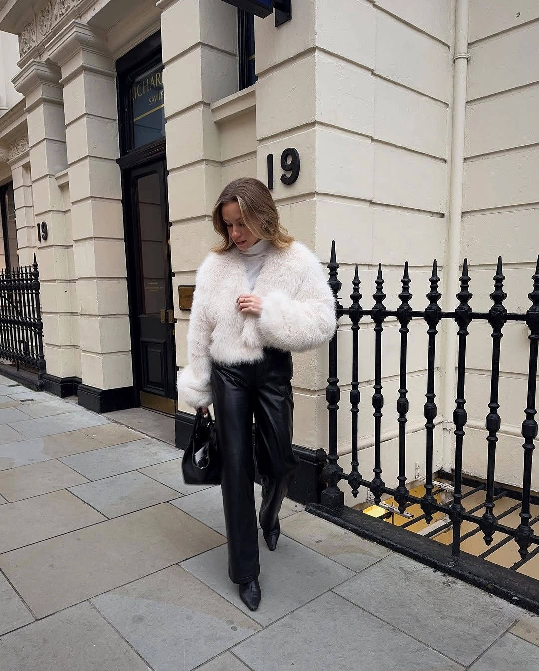 White cropped textured jacket with black straight-leg pants and pointed boots
