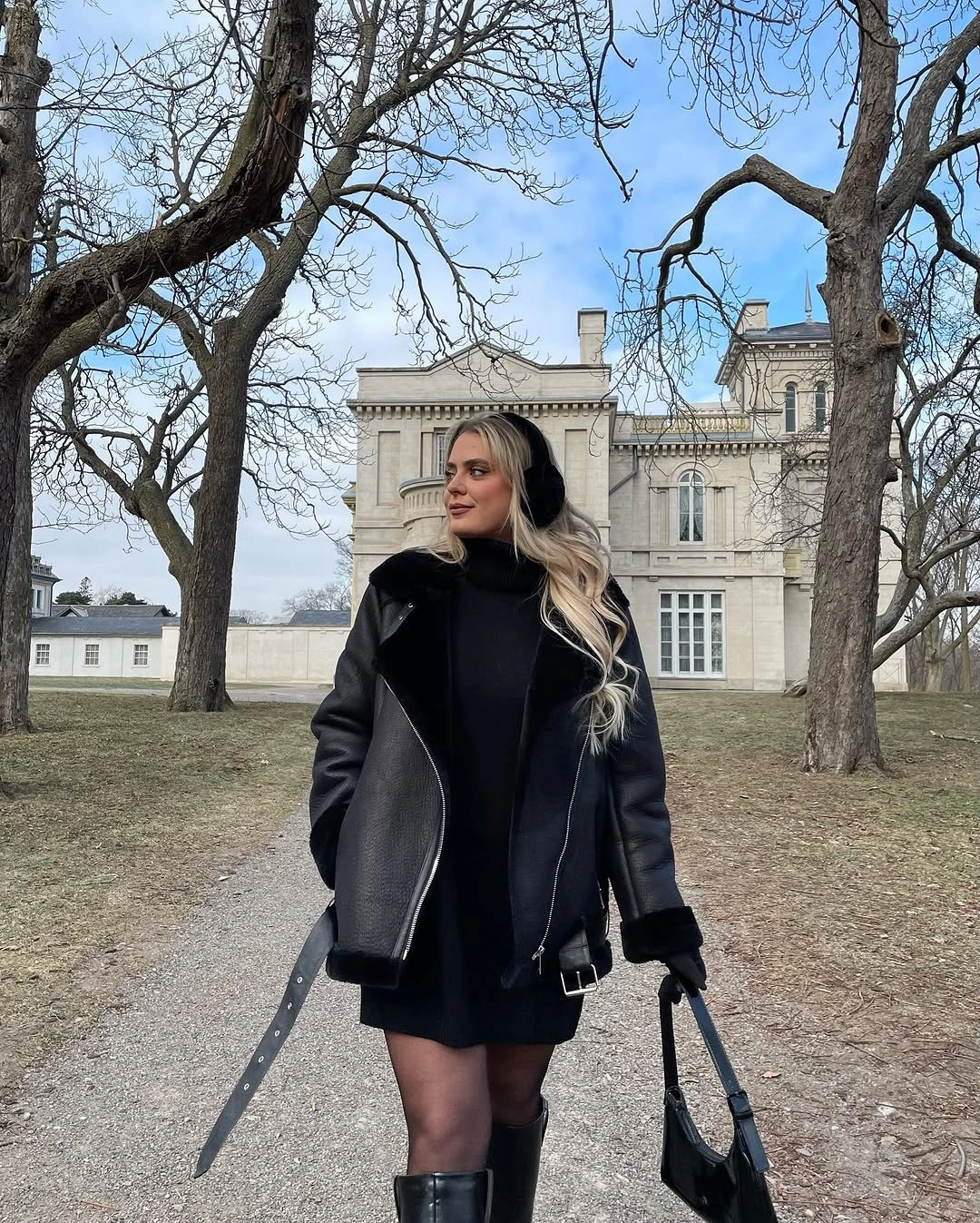 Black moto-style jacket with mini hem, tights, and tall boots