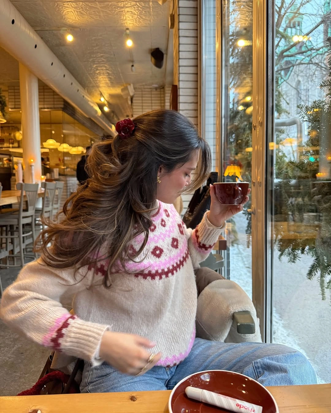 Cream patterned sweater with pink accents and light blue jeans