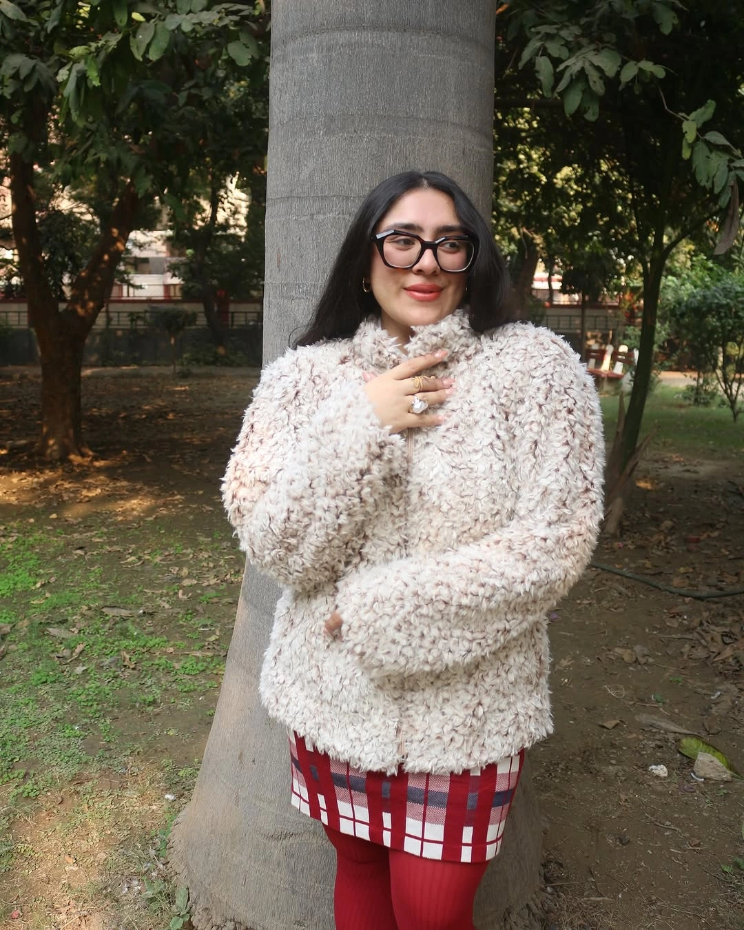 Cream fuzzy-looking sweater with red plaid skirt and red tights