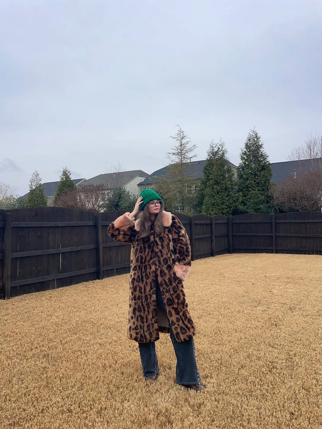 Long leopard-pattern coat with green cap and dark wide jeans