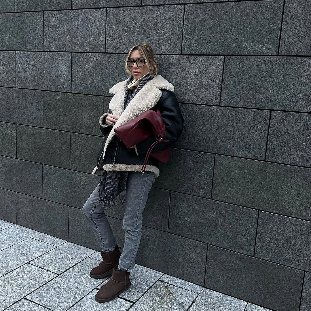 Black shearling-style jacket, gray scarf, gray jeans, burgundy tote