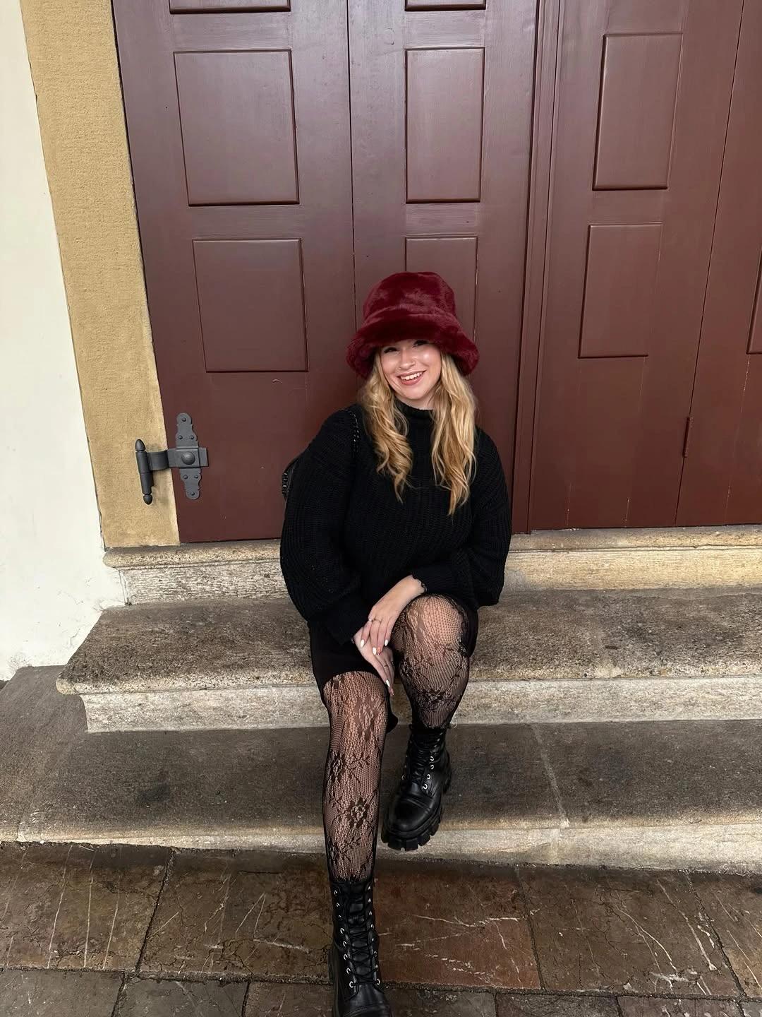 Burgundy bucket hat with black sweater, patterned tights, lace-up boots