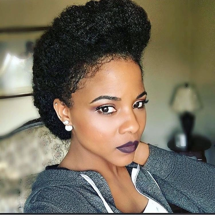 Deep black hair arranged in tall sculpted high updo