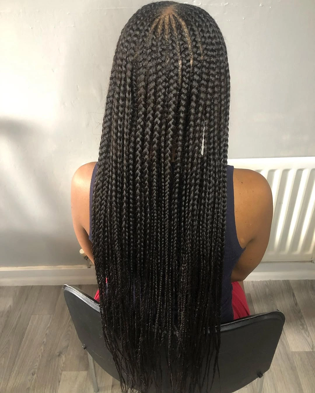 Very long black individual braids with visible crown parting