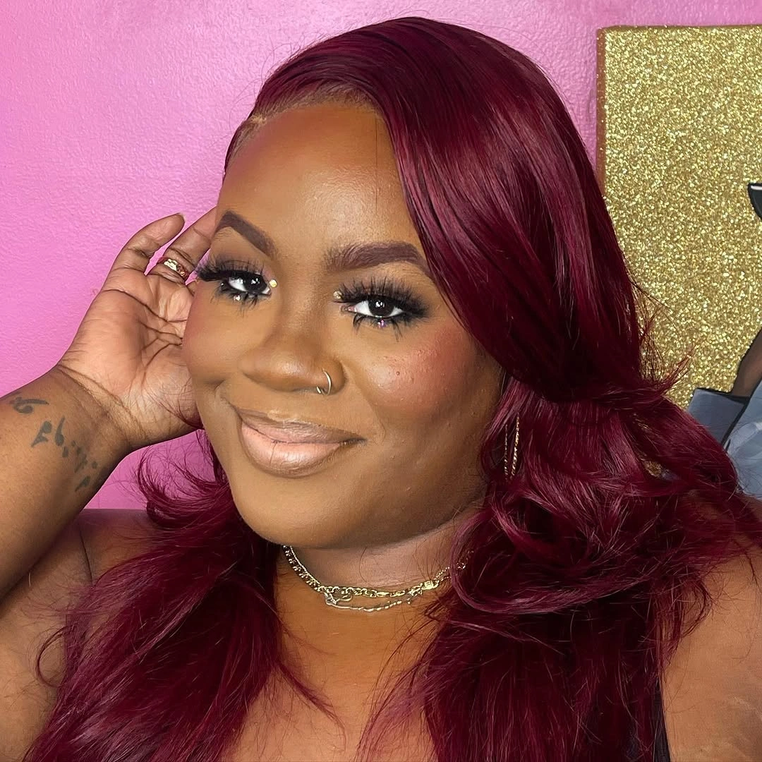Long burgundy hair with side part and large glossy curls