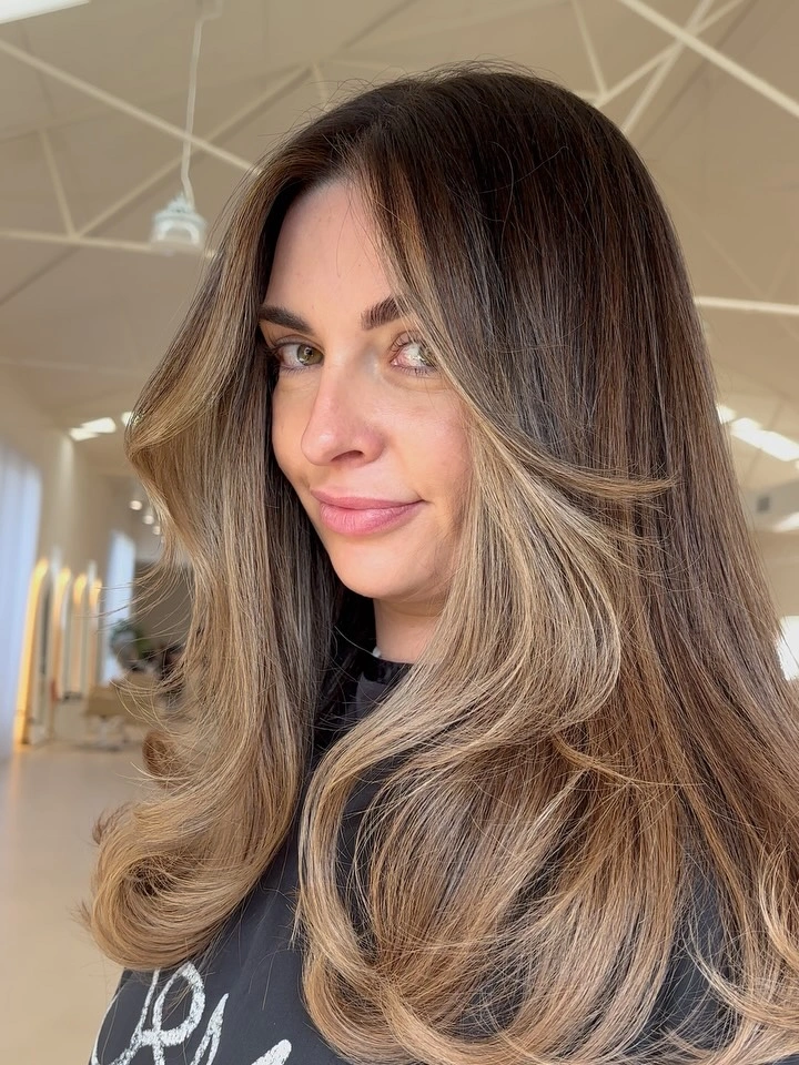 Long brunette blowout with golden beige money pieces