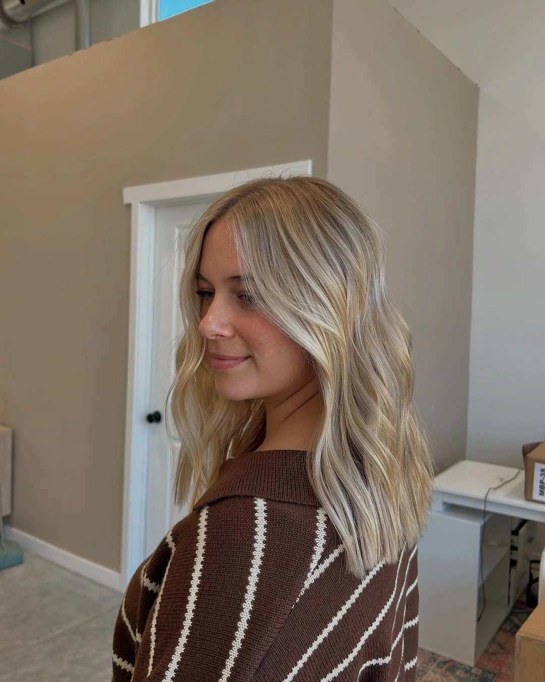 Shoulder-length blonde hair with center part and soft waves