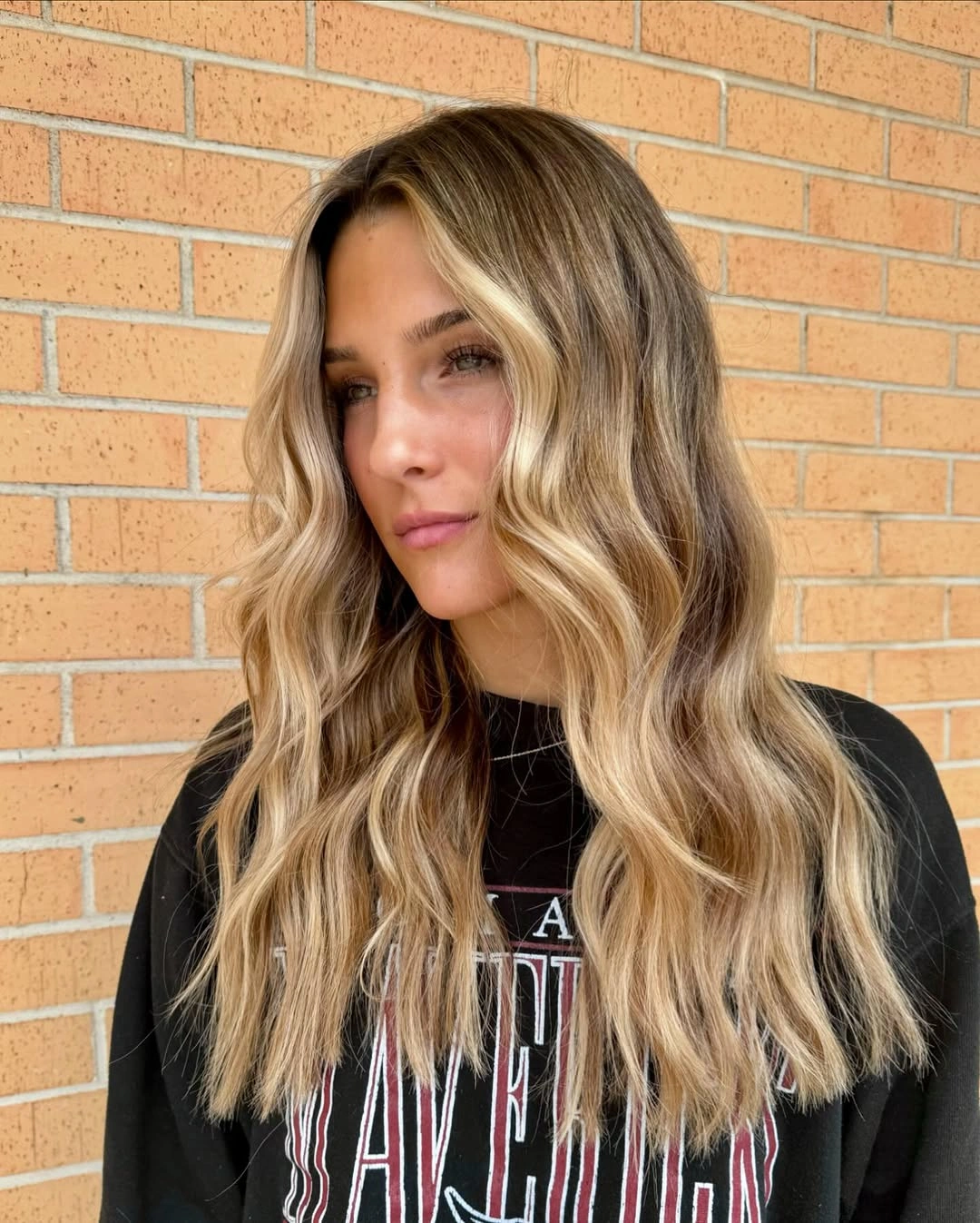 Long blonde hair with center part and shorter face-framing pieces