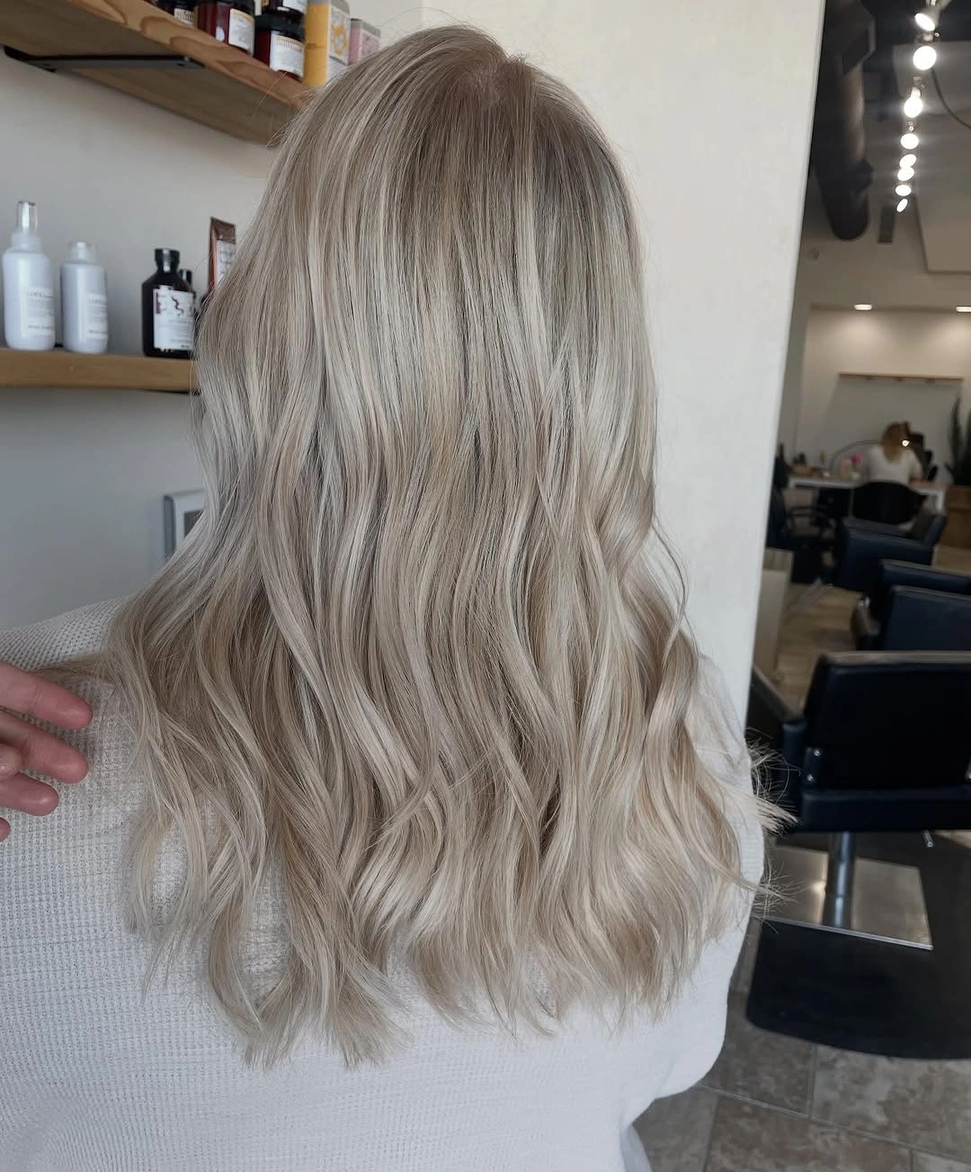Long pale blonde hair with soft waves and wispy tapered ends